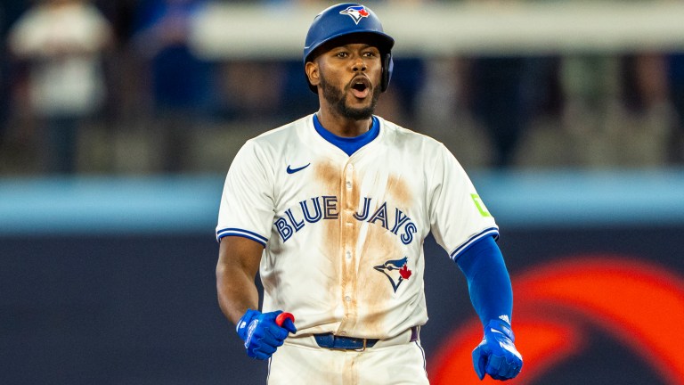 Blue Jays infielder Luis De Los Santos celebrates a base hit on second.