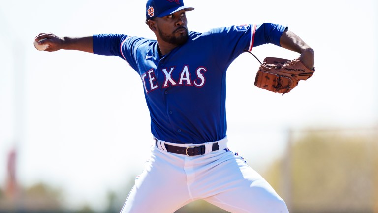 Kumar Rocker of the Texas Rangers delivers a pitch during a spring training team workout at Surprise Stadium.